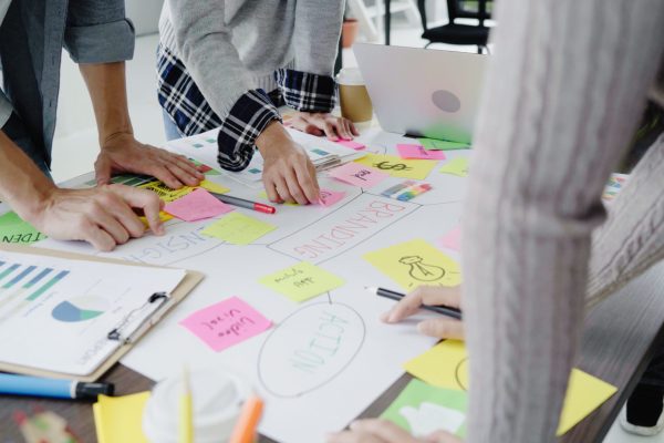 Group of casually dressed business people discussing ideas in the office. Creative professionals gathered at the meeting table for discuss the important issues of the new successful startup project.